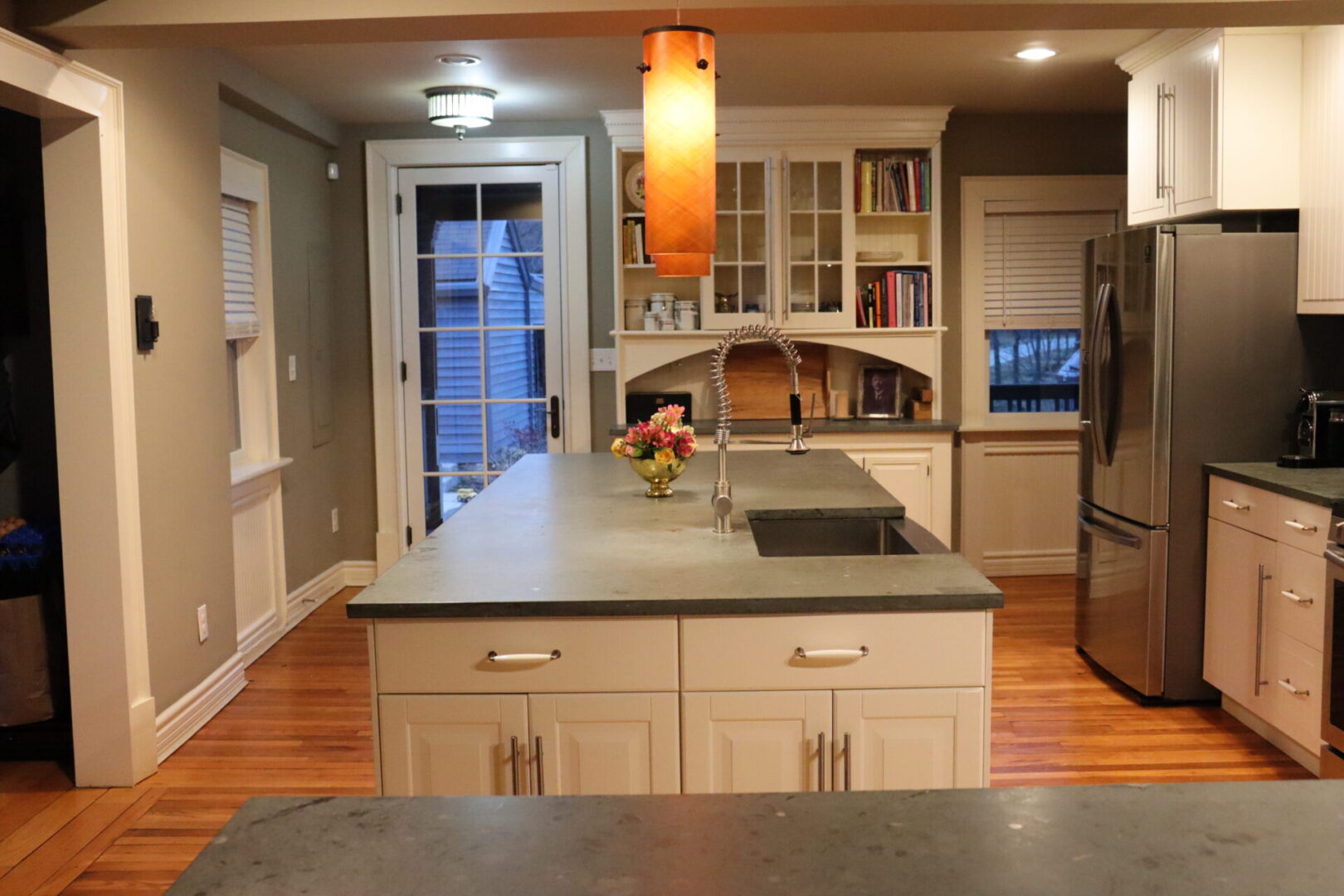 Grey-walled kitchen space with white cabinetry, silver appliances, and grey countertops