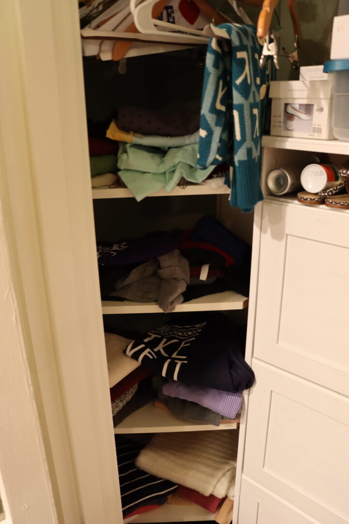 Disorganized shelves of a closet cabinet