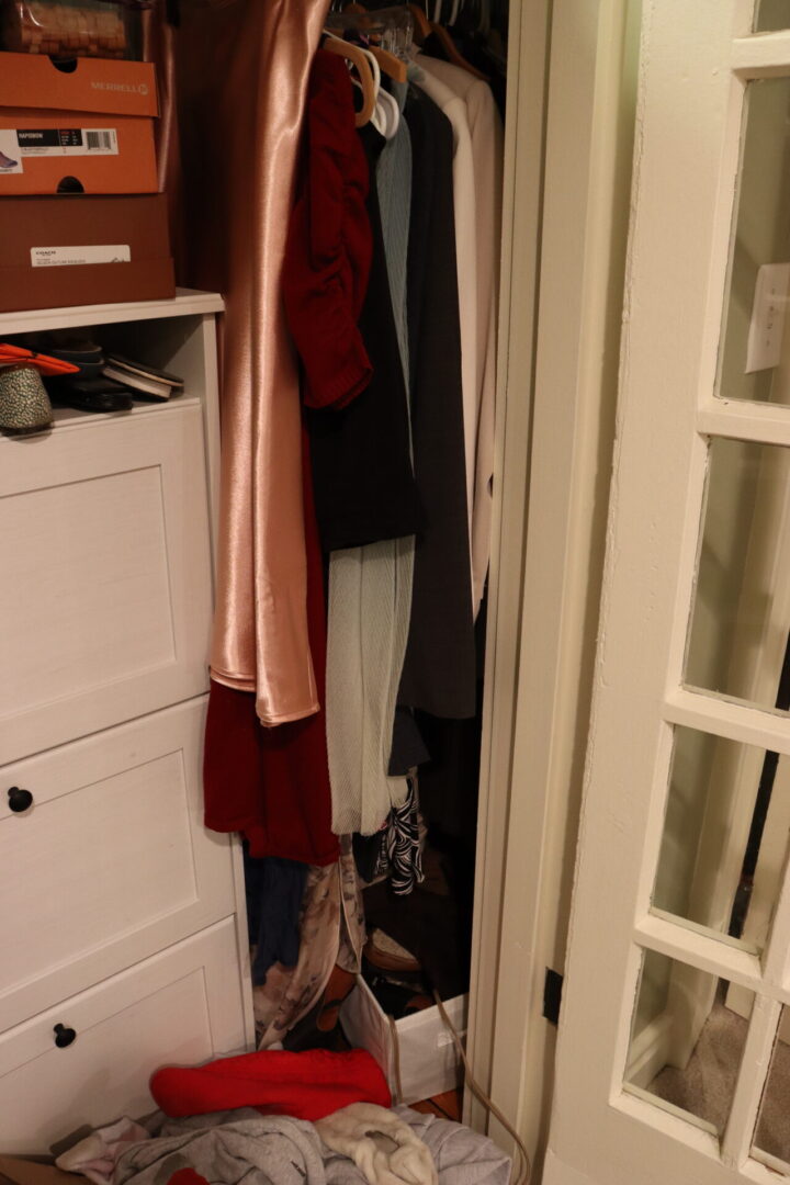 Disorganized closet cabinet with dresses