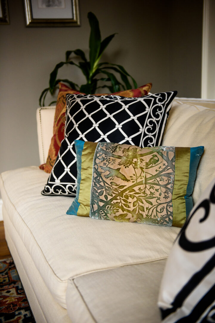 Differently designed throw pillows on a white couch